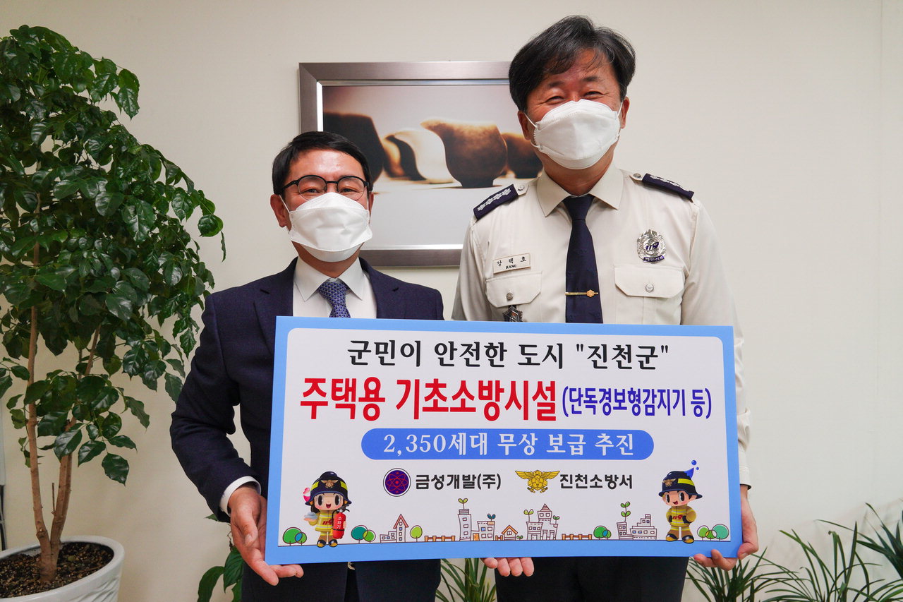 신현창 금성개발㈜ 사장이 2일 강택호 진천소방서장에게 '화재취약계층을 위한 주택용소방시설'을 기탁하고 있다.