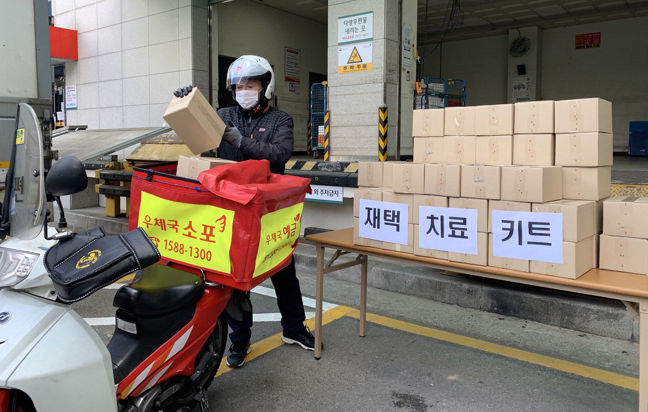 대전 둔산우체국 집배원이 16일 코로나19 재택치료자들에게 배송할 재택치료키트 상자를 싣고 있다. / 우정사업본부