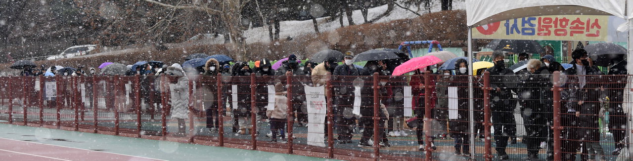 눈이 내린 15일 청주시 서원구 선별진료소에서 시민들이 검사를 기다리고 있다. 충북도에 따르면 이날 0시 기준 전일(14일) 충북지역 코로나19 신규 확진자 수가 1천327명으로 집계됐다. /김명년