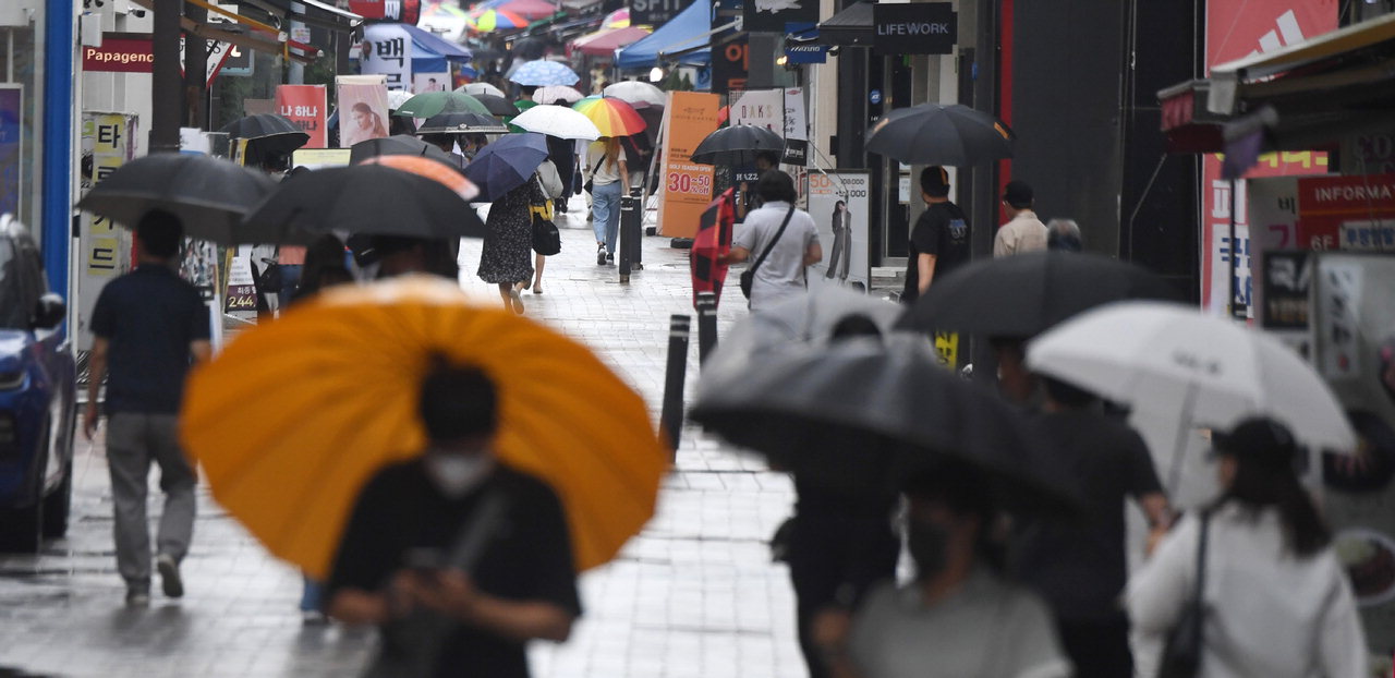장마가 시작된 23일 청주시 상당구 성안길에서 시민들이 우산을 쓴 채 발걸음을 재촉하고 있다. /김명년
