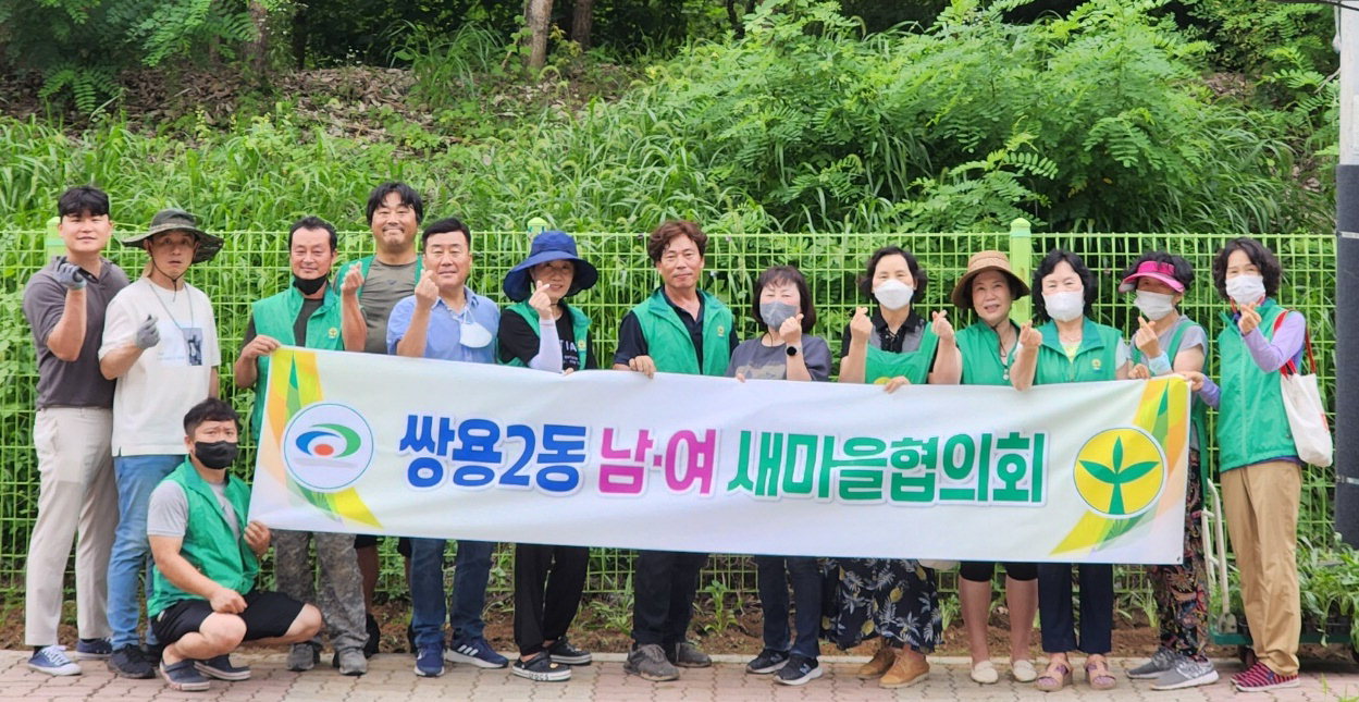 천안시 쌍용2동 새마을협의회 회원들과 직원들이 지난 14일 아름다운 꽃길 조성을 위해 꽃을 식재하고 있다./천안시