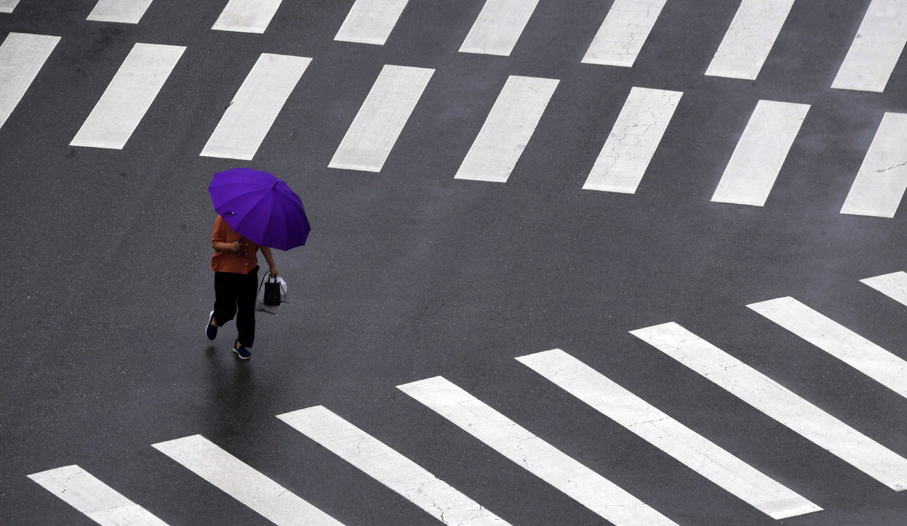 충북지역에 많은 양의 비가 내린 18일 청주시 서원구의 한 횡단보도에서 한 시민이 우산을 쓴 채 발걸음을 재촉하고 있다. /김명년