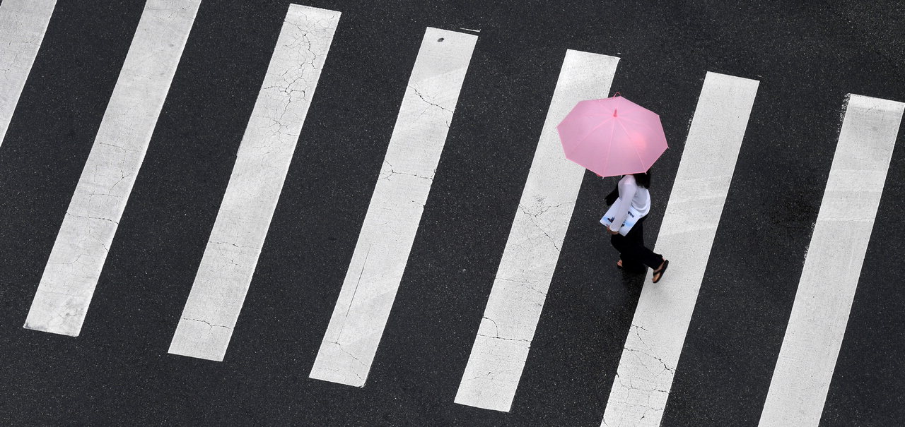 충북지역에 많은 양의 비가 내린 18일 청주시 서원구의 한 횡단보도에서 한 시민이 우산을 쓴 채 발걸음을 재촉하고 있다. /김명년