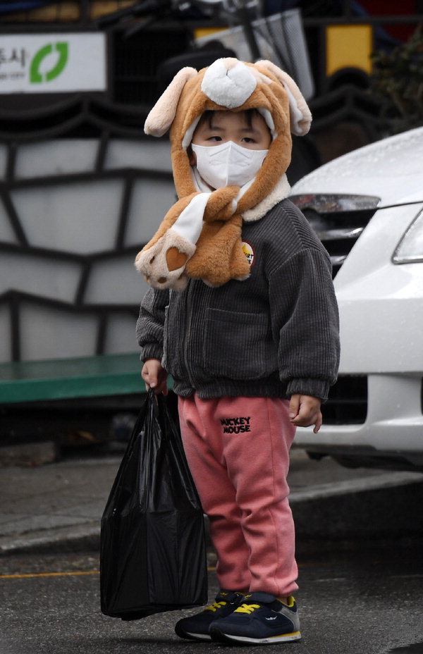 전국에 내린 가을비로 쌀쌀한 날씨를 보인 10일 청주육거리종합시장에서 한 아이가 털모자를 쓰고 있다. /김명년
