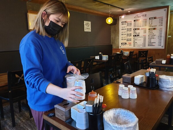 일회용품 규제 확대 시행을 하루 앞둔 23일 충북대학교 인근 식당에서 한 직원이 종이컵을 유리컵으로 교체하고 있다. / 이성현