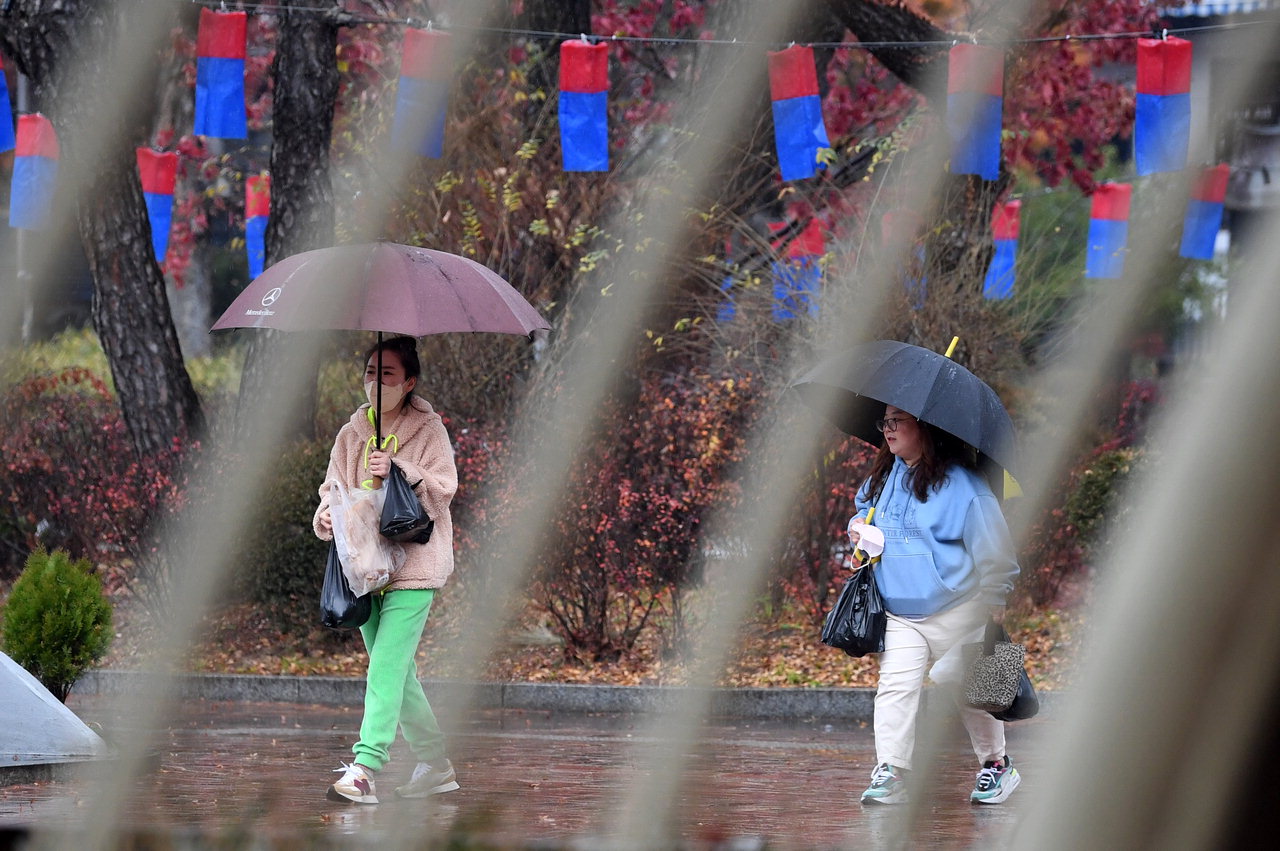 비가 내린 28일 청주 상당공원에서 우산을 쓴 시민들이 걸어가고 있다. /김명년