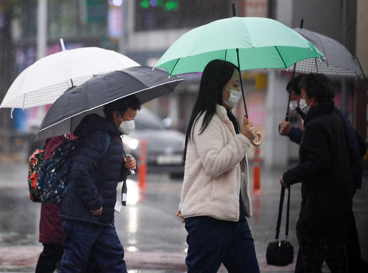 비가 내린 28일 청주시 상당구 석교육거리에서 우산을 쓴 시민들이 발걸음을 재촉하고 있다. /김명년