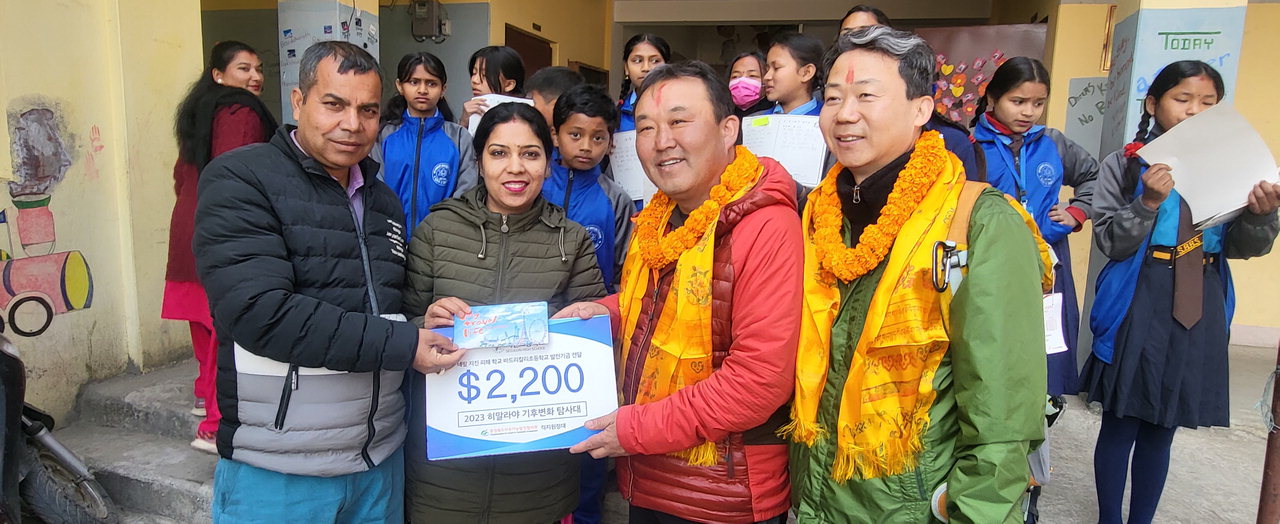 박연수 히말라야기후변화탐사대장이 진천 서전고 학생들과 충북의 각계 인사들이 참여해 마련한 기부금을 네팔 바드라칼리 초등학교 관계자에게 전달하고 있다. /히말라야기후변화탐사대