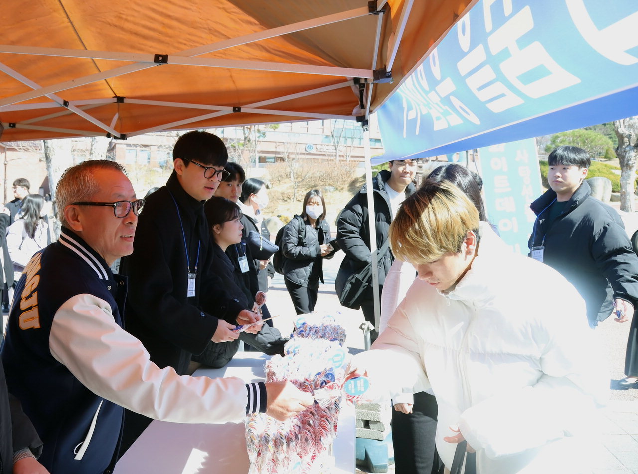 차천수 청주대 총장이 13일 오전 대학 중문 인근에서 화이트데이를 앞두고 학생들에게 간식을 나눠주고 있다.