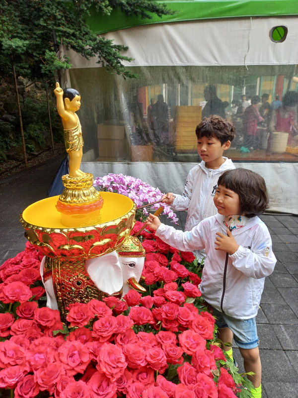 27일 대전 유성구 구암사에서 아기 부처님께  감차(甘茶)를 뿌리며 공양하는 행사인 관불의식에 참여한 어린이들 모습. /장중식