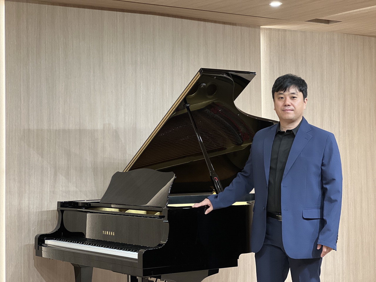 이훈희 공연세상 대표가 지난 21일 북문누리아트홀에 마련된 피아노 앞에서 환하게 웃고 있다. / 박은지