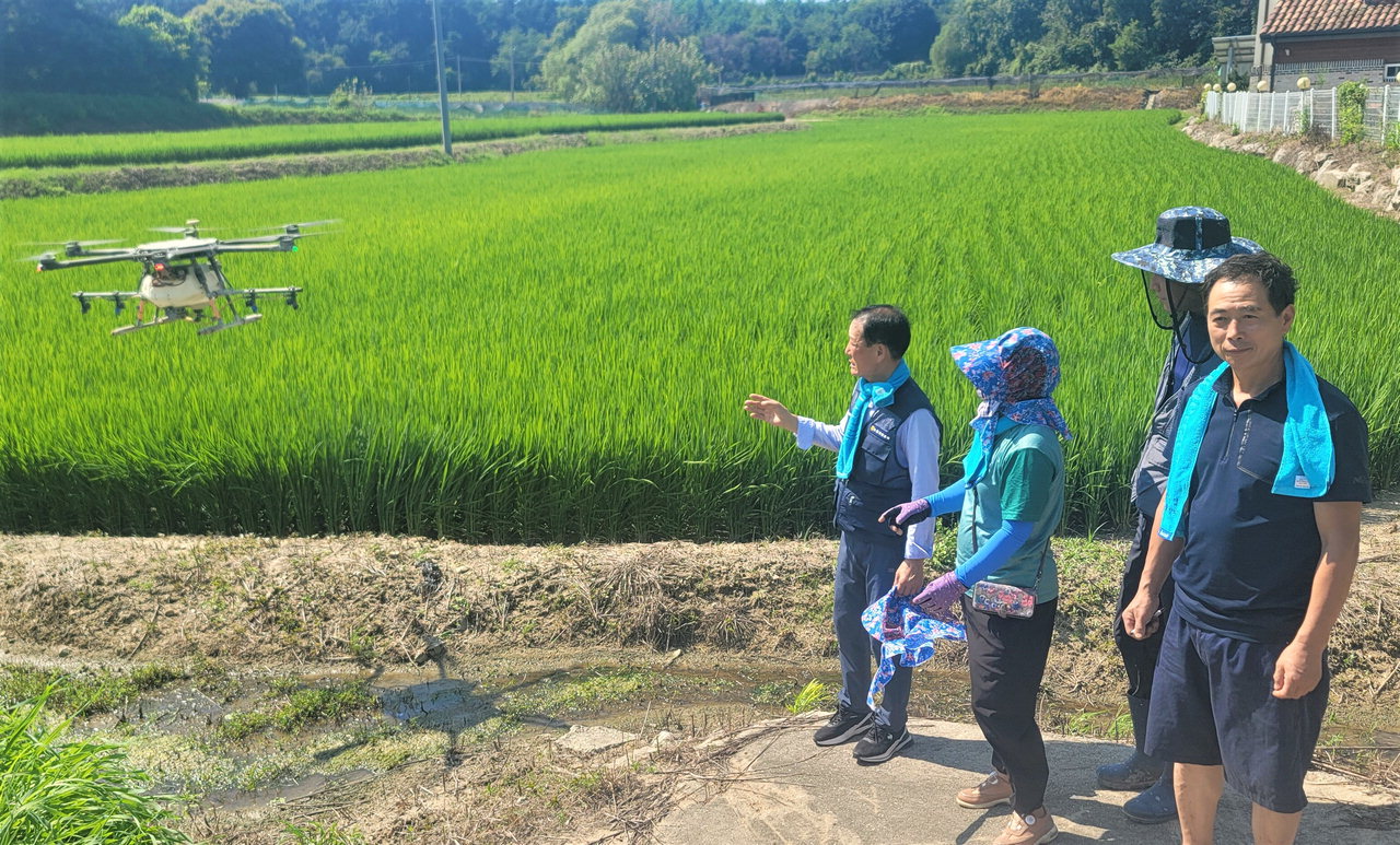 이길웅(왼쪽 첫 번째) 조합장이 농업인들과 함께 항공방제 현장을 둘러보고 있다./충북농협