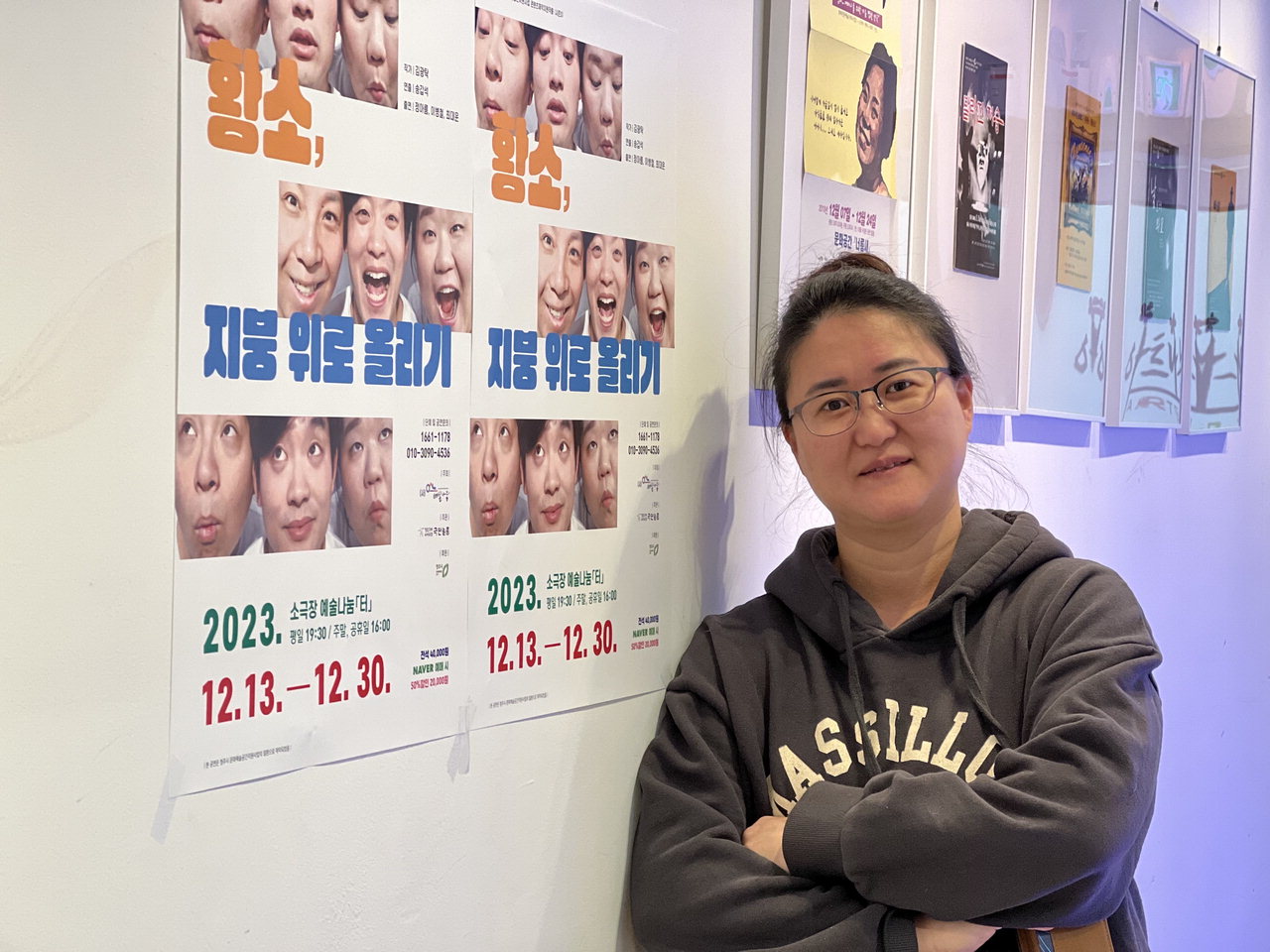 천은영 예술나눔터 대표가 지난 18일 공연장 포스터앞에서 환하게 웃고 있다.  / 박은지