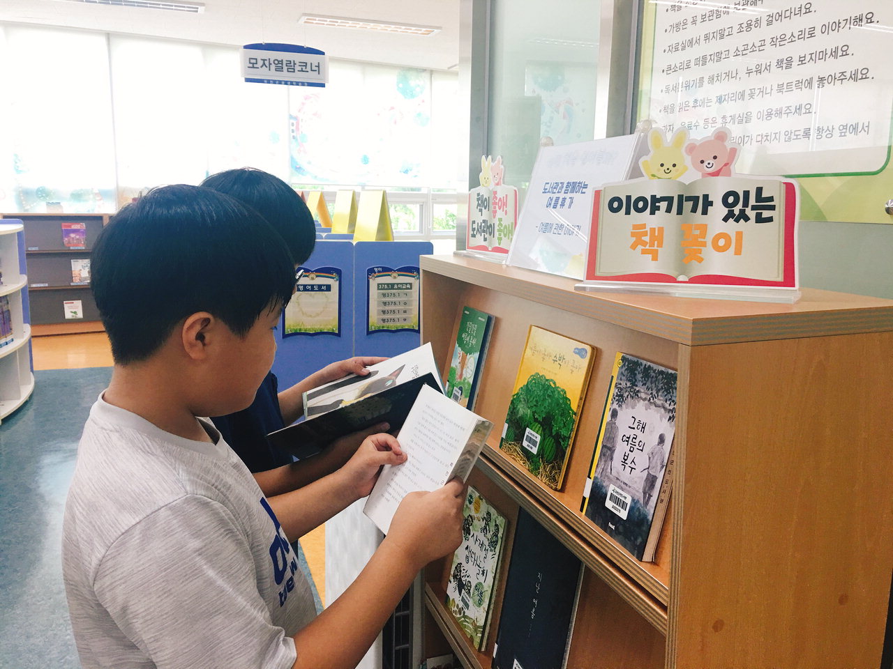 어린이들이 옥천군민도서관 북큐레이션 서가에서 책을 고르고 있다. / 옥천군 제공