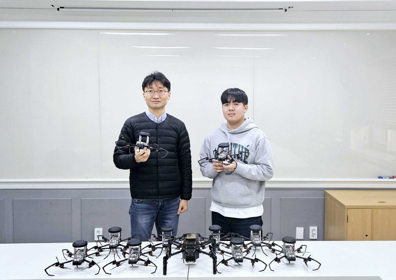 문성태(왼쪽) 충북대 전자공학부 교수와 송시운 학생이 군집드론쇼에 활용되는 기체를 선보이고 있다.