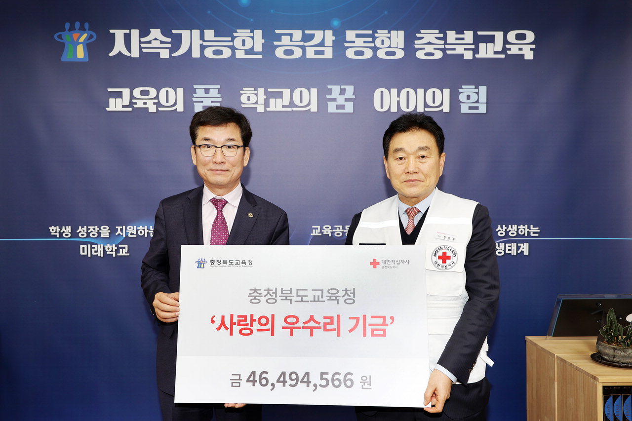 윤건영(왼쪽) 충북도교육감이 장현봉 대한적십자사 충북지사회자에게 4천600여만원의 우수리 모금액을 전달했다.