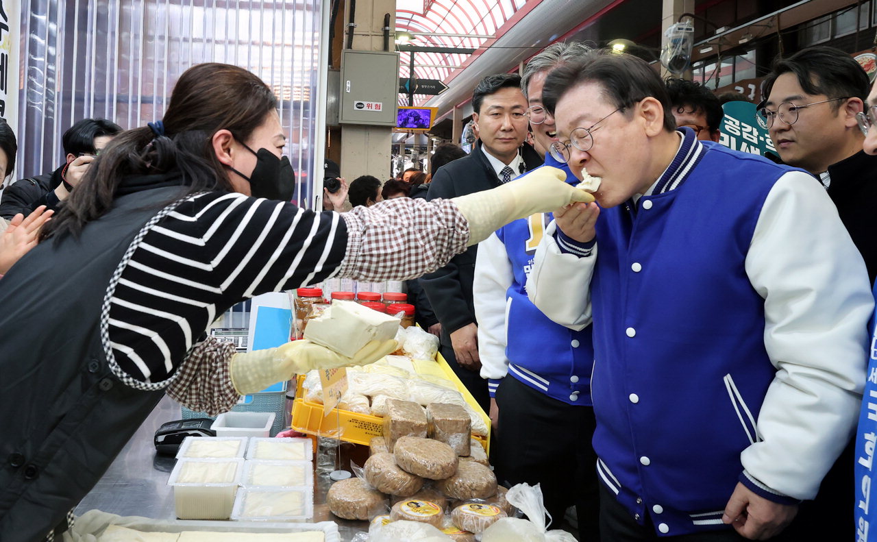 이재명 더불어민주당 당 대표가 14일 청주육거리시장에서 시장상인이 건넨 두부를 먹고 있다. /신동빈