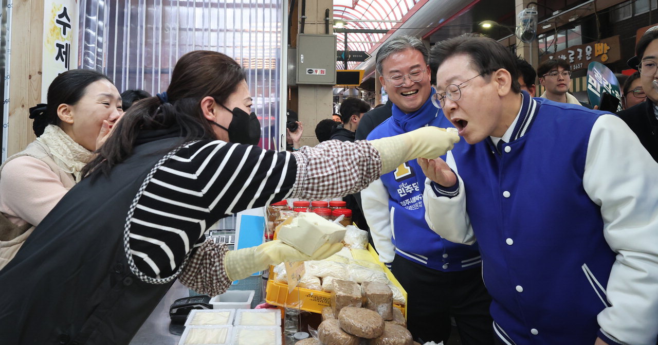 이재명 더불어민주당 당 대표가 14일 청주육거리시장에서 시장상인이 건넨 두부를 먹고 있다. /신동빈