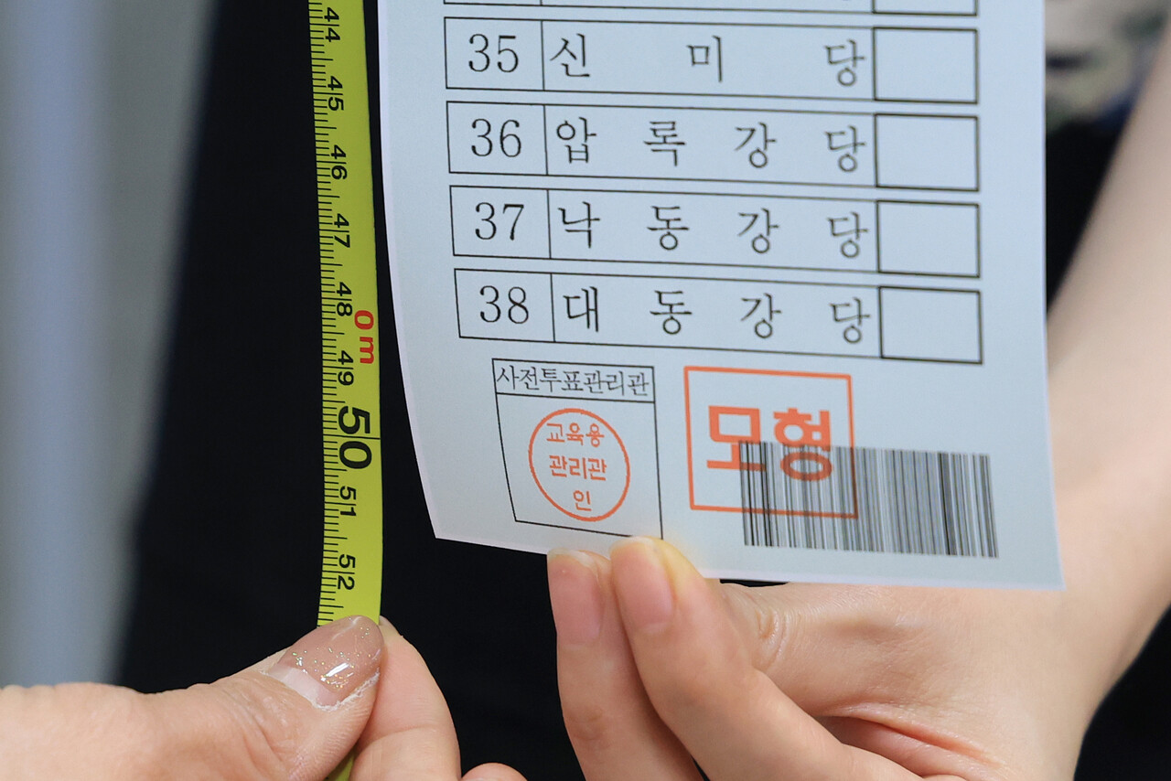 제22대 국회의원 선거를 14일 앞둔 27일 종로구 서울시선거관리위원회에서 직원이 비례대표 모의 투표용지를 들어 보이고 있다. 유권자들은 이번 총선에서 역대 가장 긴 51.7㎝에 달하는 비례대표 선거 투표용지를 받는다. /연합뉴스