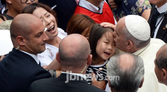 15일 성모승천 대축일 미사가 열리는 대전월드컵경기장에서 프란치스코 교황이 아이의 이마에 입맞춤하고 있다. / 사진공동취재단