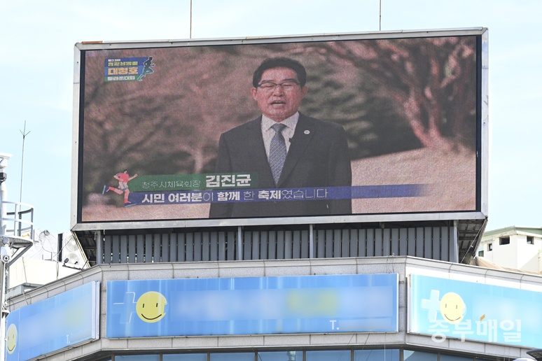 ▲ 김진균 청주시체육회장이 ‘제23회 청원생명쌀 대청호 마라톤대회’ 폐막을 축하하는 영상이 청주시 서원구 사창사거리에 위치한 전광판에서 송출되고 있다. /김성렬