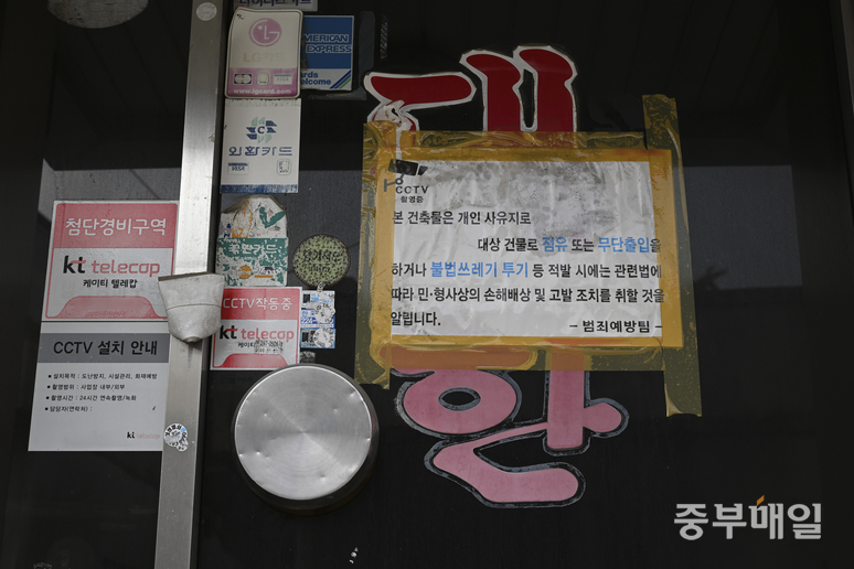 ▲ 24일 재개발이 예정된 청주시 서원구 무심천 인근 사직4구역 한 숙박업소 문에 경고문이 부착되어 있다. /김성렬